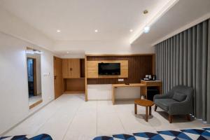 a living room with a television and a chair at Hotel Premji, Dwarka in Dwarka