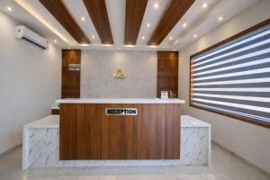 a reception desk in a lobby with a sign on it at Hotel Premji, Dwarka in Dwarka