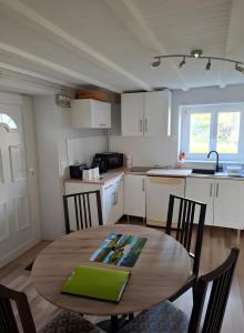 a kitchen with a wooden table and a table and chairs at Le Puy D'Eraigne in Saint-Nectaire