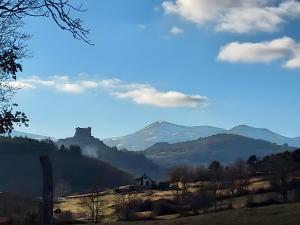 a house on a hill with mountains in the background at Le Puy D'Eraigne in Saint-Nectaire