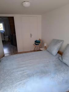 a large white bed in a room with a door at Le Puy D'Eraigne in Saint-Nectaire