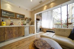 a living room with a couch and a kitchen at Sunset TLV Apartment - Dizengoff 142 in Tel Aviv