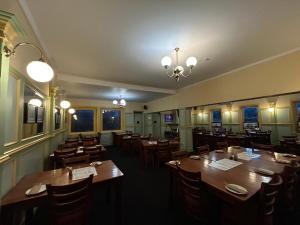 a restaurant with wooden tables and chairs and a chandelier at Tailem Bend Hotel in Tailem Bend