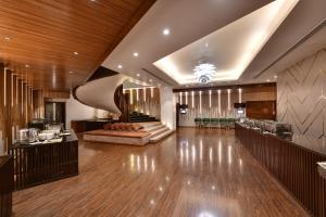 a lobby with wooden floors and a staircase in a building at Hotel Suba International Sahar Road Mumbai in Mumbai