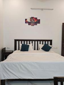 a large bed with white sheets and blue pillows at Brahma Heritage Resort in Pushkar