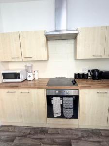 a kitchen with a stove and a microwave at Relaxing Private Bedroom Stay in Hull