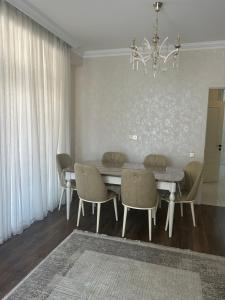 a dining room with a table and chairs and a chandelier at Light & Comfortе in Mekhrably +6 photos