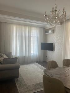 a living room with a chandelier and a table and chairs at Light & Comfortе in Mekhrably