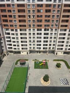 a person playing a game of golf in front of a large building at Light & Comfortе in Mekhrably