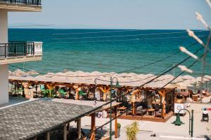 Blick auf einen Strand mit Sonnenschirmen und dem Meer in der Unterkunft Hotel White Rose Beach in Olympiakí Aktí
