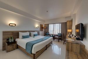 a hotel room with a large bed and a desk at Hotel Suba International Sahar Road Mumbai in Mumbai +62 photos