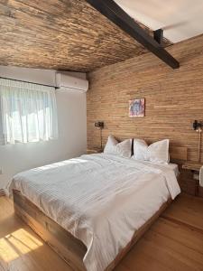 a large bed in a bedroom with a brick wall at Stone Village Transfagarasan in Oeștii Ungureni