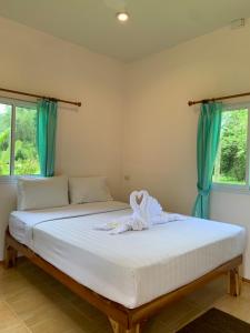a bedroom with a large bed with blue curtains at Khaosok Bamboo Huts Resort in Khao Sok National Park
