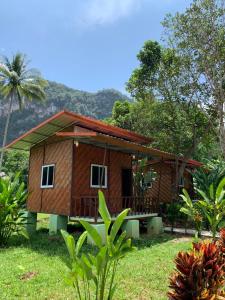 a small house in the middle of a field at Khaosok Bamboo Huts Resort in Khao Sok National Park