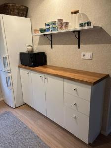 a kitchen with a counter with a microwave and a refrigerator at En mysig liten Stuga nära naturen och havet in Västlax