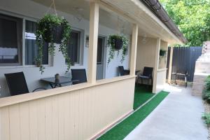 a porch of a house with chairs and plants at Elegant City Home-Free Parking in Timişoara