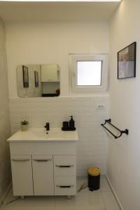 a white bathroom with a sink and a mirror at Elegant City Home-Free Parking in Timişoara +24 photos