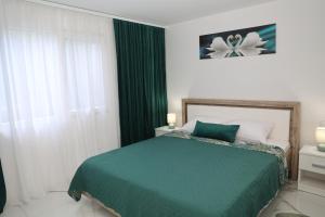 a bedroom with a green bed and a window at Elegant City Home-Free Parking in Timişoara