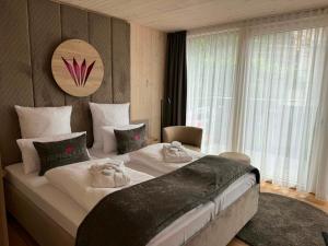 a bedroom with a large bed with towels on it at Felsenland BERGVILLEN in Dahn
