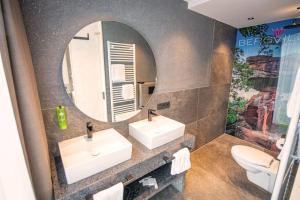 a bathroom with two sinks and a mirror at Felsenland BERGVILLEN in Dahn +24 photos
