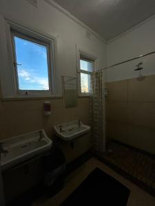 a bathroom with two sinks and a window at Tailem Bend Hotel in Tailem Bend