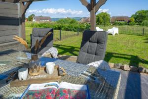 a picnic table with a book on it in a yard at Reethaus Zickersche Berge - WG 02 mit Kamin und Terrasse in Gager