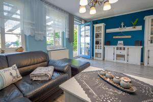 a living room with a leather couch and a table at Reethaus Zickersche Berge - WG 02 mit Kamin und Terrasse in Gager