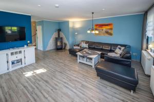 a living room with a couch and a tv at Reethaus Zickersche Berge - WG 02 mit Kamin und Terrasse in Gager +20 photos
