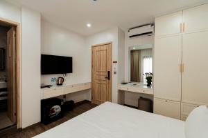a bedroom with a bed and a flat screen tv at The Serenity Hanoi in Hanoi