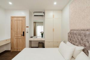 a bedroom with a white bed and a sink at The Serenity Hanoi in Hanoi