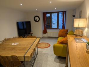 a living room with a table and a yellow couch at La Cachette Floracoise in Florac