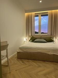 a bedroom with a large bed and a window at Kresowy View Apartment in Biłgoraj