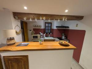 a kitchen with a wooden counter top with a table at La Cachette Floracoise in Florac
