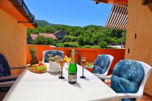 a table with a bottle of wine and wine glasses at Holiday Home Rocca with pool in Vrgorac