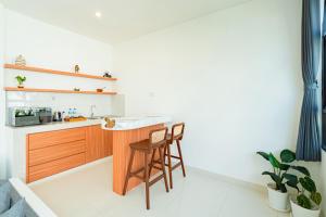 a kitchen with a counter and a bar with a stool at Dita Villa Uluwatu in Bingin Beach
