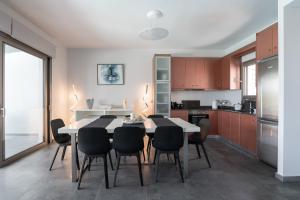 a kitchen and dining room with a table and chairs at St Aims by Bluesites in Porto Heli