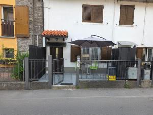 a gate with an umbrella in front of a building at Casa Marconi 1 piano in Pisogne