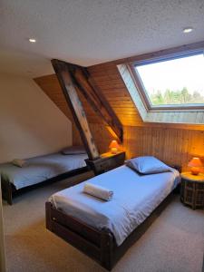 a attic bedroom with two beds and a skylight at B&B Gite les Baudy in Le Haut-du-Them