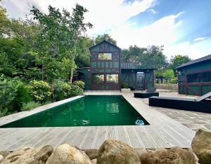 ein Haus mit Swimmingpool im Garten in der Unterkunft Chalet Green in Tbilisi City