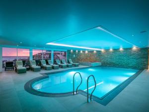 a large swimming pool in a building with chairs at Atlantis in St Ives