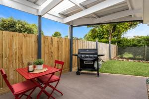 a patio with a grill and a table and chairs at Golfside Getaway 2 by Ready Set Stay in Rosebud