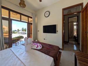 a bedroom with a bed with a clock on the wall at Villa Goli 3BR Private Pool Villa, Paje in Zanzibar City