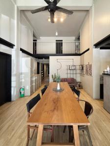 a dining room with a wooden table and a ceiling fan at Monomer Hostel Bangkok in Bangkok