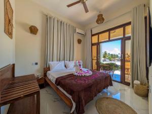 a hotel room with a bed and a balcony at Villa Goli 3BR Private Pool Villa, Paje in Zanzibar City