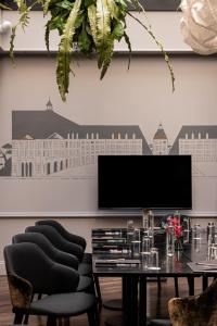 a dining room with a table and black chairs at Villas Foch Boutique Hotel & Spa Bordeaux in Bordeaux