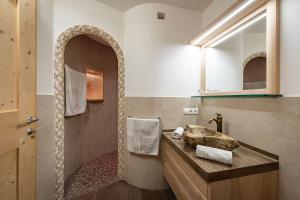 a bathroom with a stone sink and a mirror at Moarlhof - Farm Nature Resort in Castelrotto +60 photos