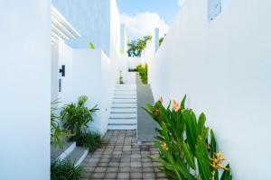 a white alleyway with white walls and plants at Dita Villa Uluwatu in Bingin Beach