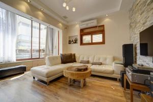 een woonkamer met een bank, een tafel en een tv bij Sunset TLV Apartment - Dizengoff 142 in Tel Aviv