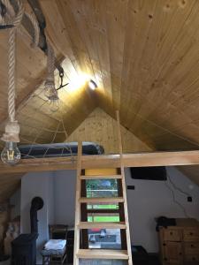a loft bed in a room with a wooden ceiling at Dolina Izerów in Sucha +6 photos