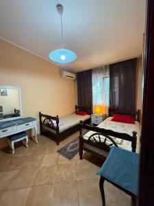 a bedroom with two beds and a desk and a table at Maja Apartmani in Sutomore